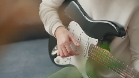 las manos de una mujer irreconocible aprendiendo a tocar la guitarra eléctrica 1