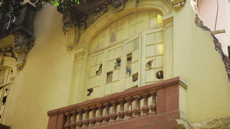 the windows of a formerly beautiful old building are broken, now derelict and abandoned in colonia juárez, mexico city