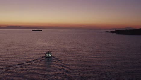 aerial - fishing boat at dusk in vouliagmeni, greece