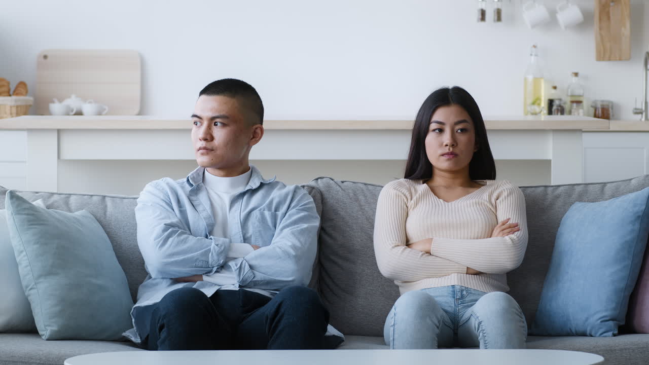 una pareja discutiendo en el sofá.