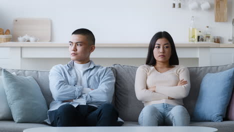 una pareja discutiendo en el sofá.