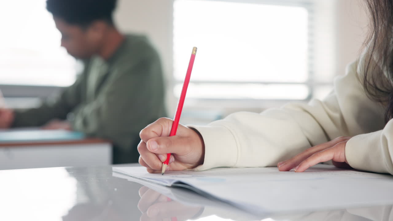 Students in a classroom writing on paper with pencils