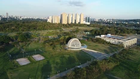 drone flying towards a beautiful nursery located in a public park full of lush vegetation, tranquility, nature, calm, peace, in 4k resolution