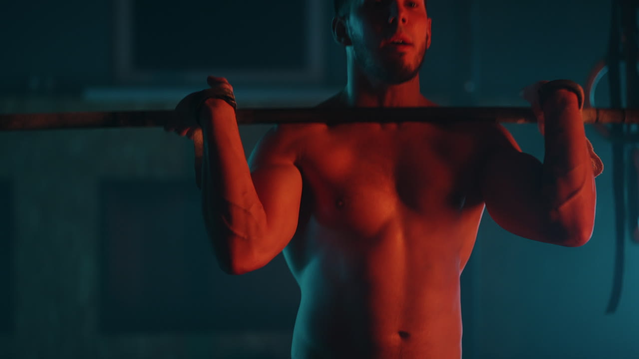 uomo sportivo sta sollevando la barra in palestra in allenamento notturno e si prepara alla competizione professionale