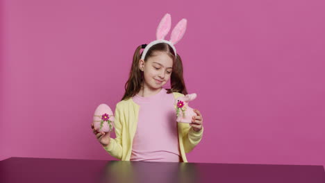 Small-cheerful-girl-showing-colorful-decorated-ornaments-on-camera