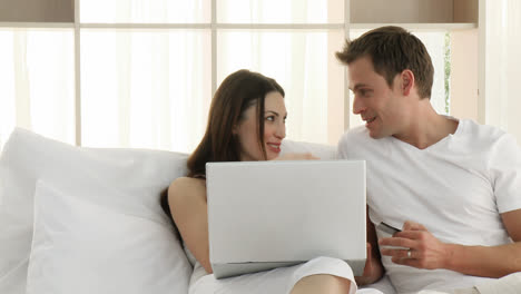 couple using a laptop in the bedroom