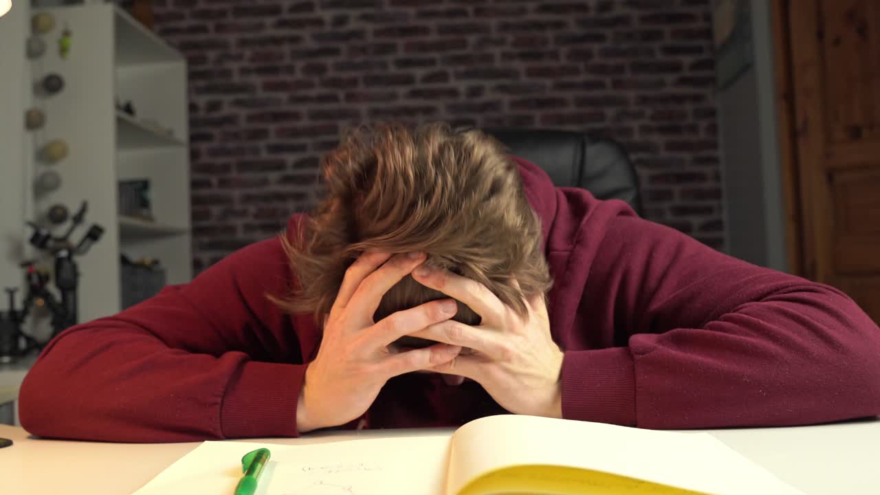 Uno studente di ingegneria è assorto nei pensieri e prende appunti.