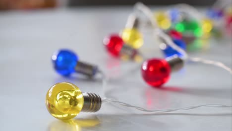 Christmas LED bulbs in festive hues—blue, red, yellow, and green—adorn a white surface