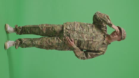 full body of asian man soldier having a headache while standing in the green screen background studio