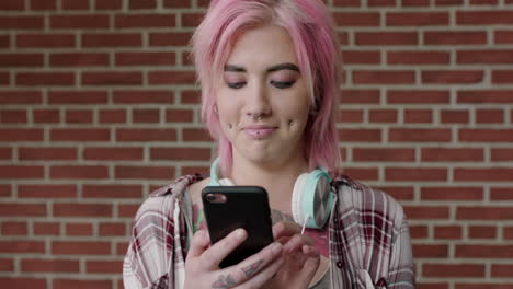 portrait-of-alternative-punk-woman-with-pink-hair-texting-browsing-social-media-using-smartphone