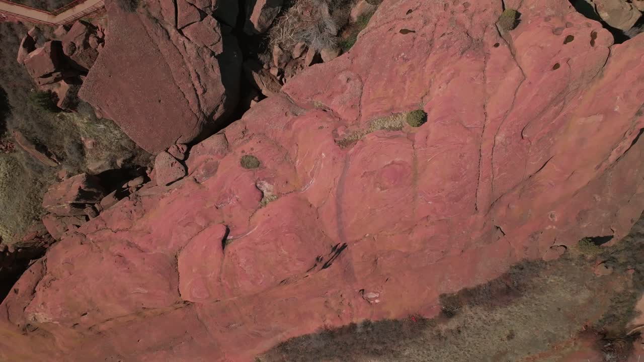 Red Rocks Park and amphitheater Morrison Colorado Birdseye view aerial drone looking down sandstone rugged Red Rocks front range foothills winter spring mountainside hills upwards spin motion