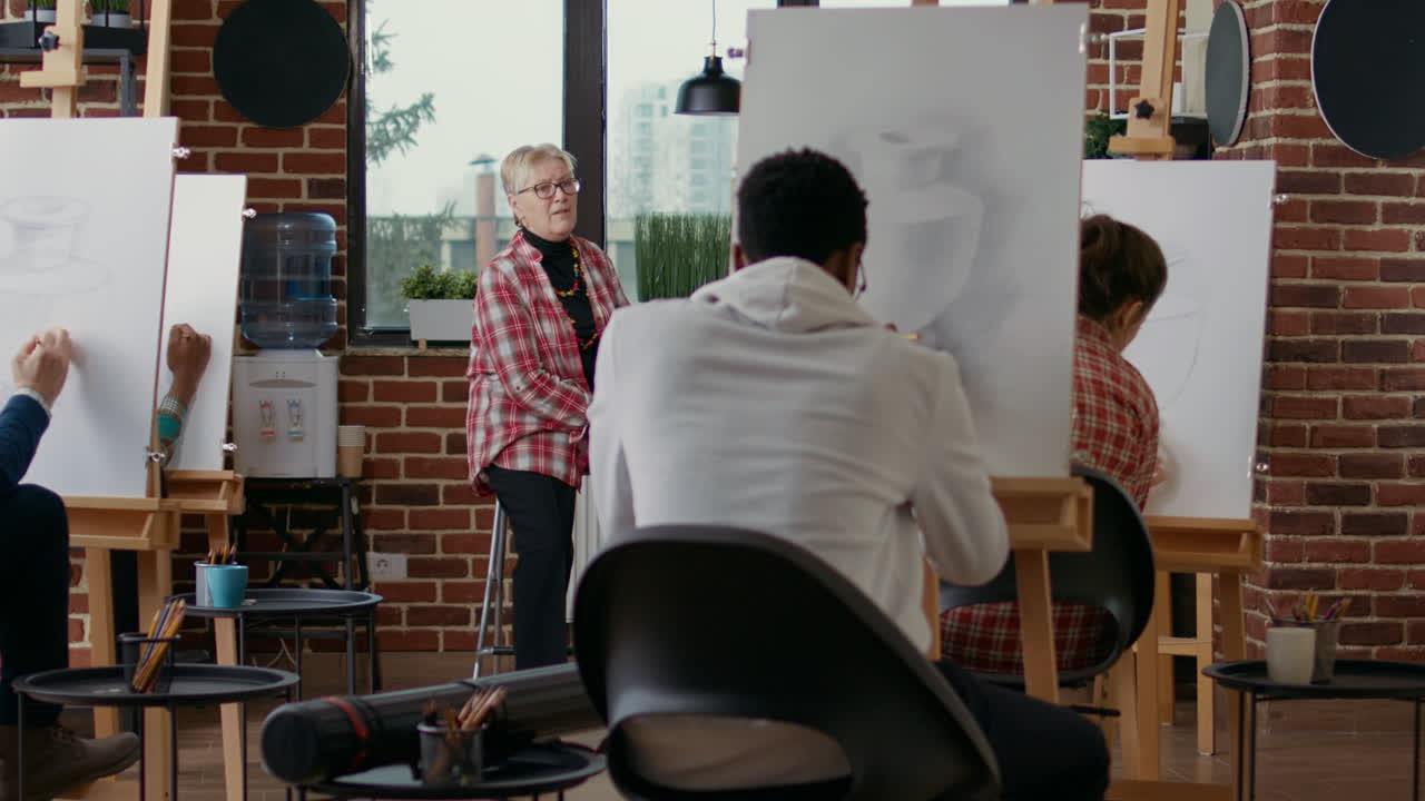 Elder teacher talking about drawing skills at art class lesson