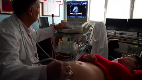 gynecologist smiling while checking baby's blood levels and heart rate during ultrasound