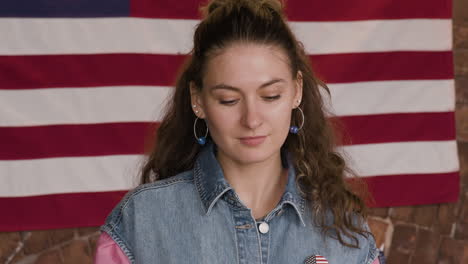 Woman Enjoying a Small Burger in Front of an American Flag