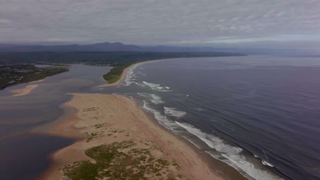 Sudáfrica-George-Mossel-Bahía-Jardín-Ruta-Playa-Aéreo-Dron-Cinemática-Fiesta-Vacaciones-Pueblo-Jeffreys-Bay-Olas-Estrellarse-Agua-Azul-Marrón-Océano-última-Hora-De-La-Mañana-Tarde-Nublado-áfrica-Dando-Vueltas-Movimiento