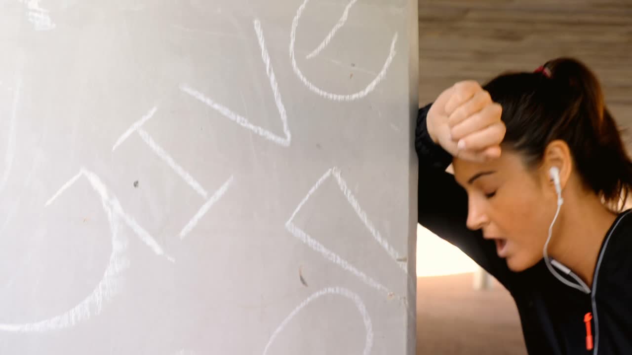 mujer de fitness agotada tomando un descanso después de correr 4k