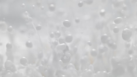 la pintura blanca salpica y crea ondas estacionarias, líquido lácteo abstracto en macro y cámara lenta