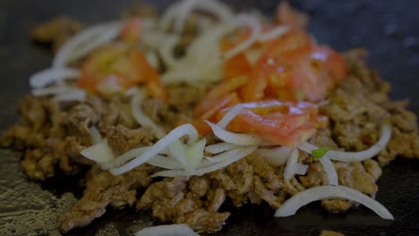 Close-Up-Shot-Of-Tasty-Philadelphia-Meat-Prepared-On-Grill-With-Onion-And-Tomato