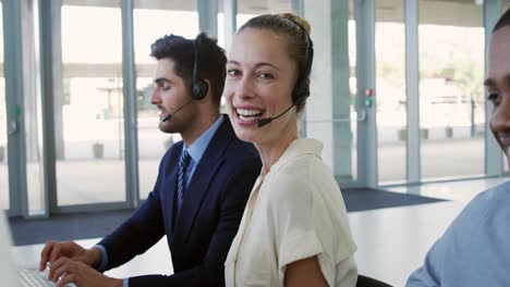 Young-business-people-wearing-headsets-in-a-modern-office