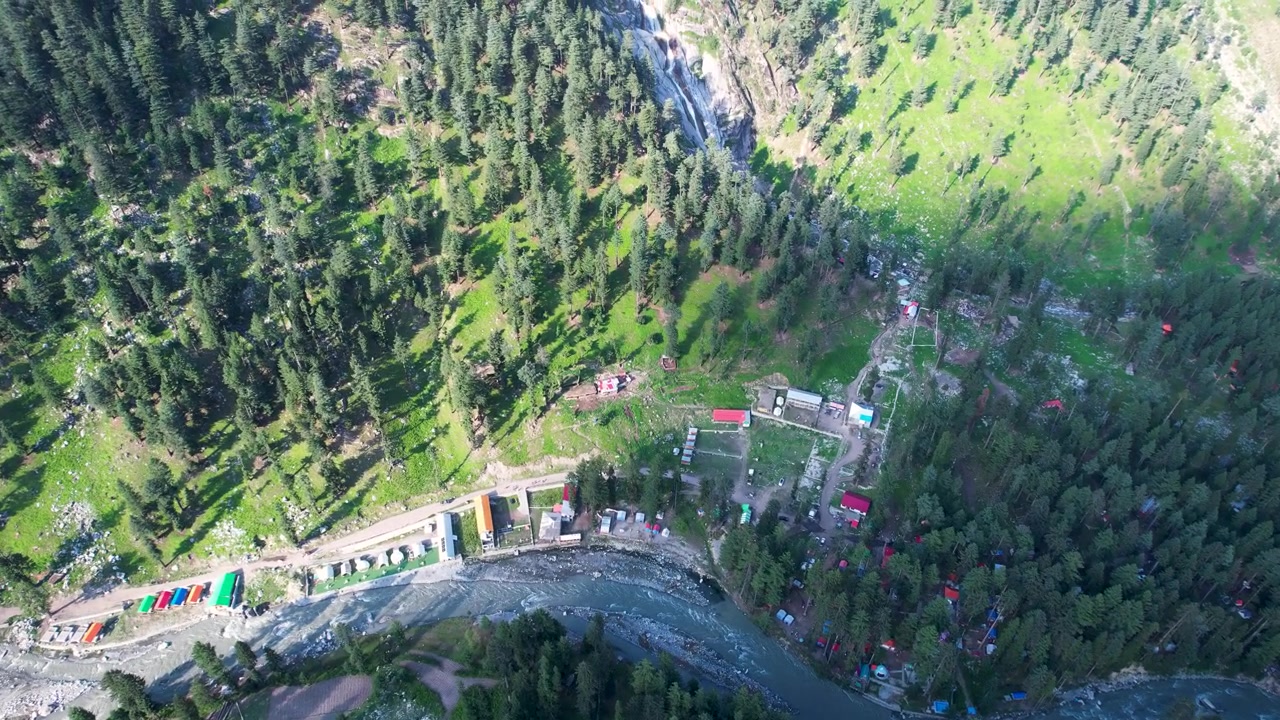 Fiume che scorre oltre accampamenti forestali con una cascata nella Valle di Kumrat, Khyber Pakhtunkhwa, Pakistan