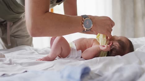 Video-Des-Mittelteils-Einer-Kaukasischen-Mutter,-Die-Ihr-Neugeborenes-Baby-Wickelt