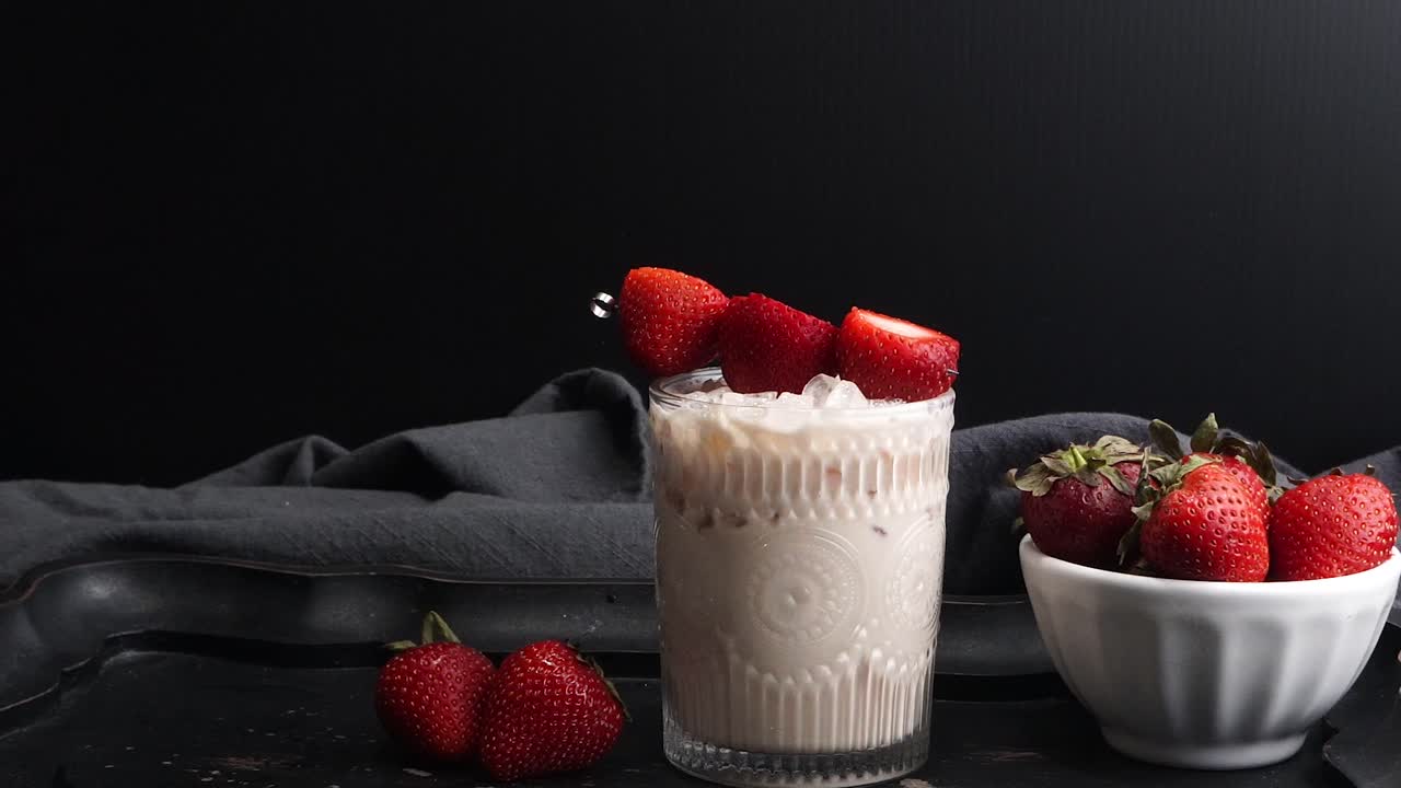 Pink cocktail drink with strawberry liqueur, vanilla vodka and cream. Party drink with strawberries. Fruit cocktail with fresh strawberries as a garnish. Cold and refreshing