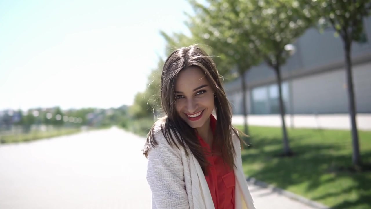 Mujer joven feliz con el pelo al viento sonriendo al aire libre