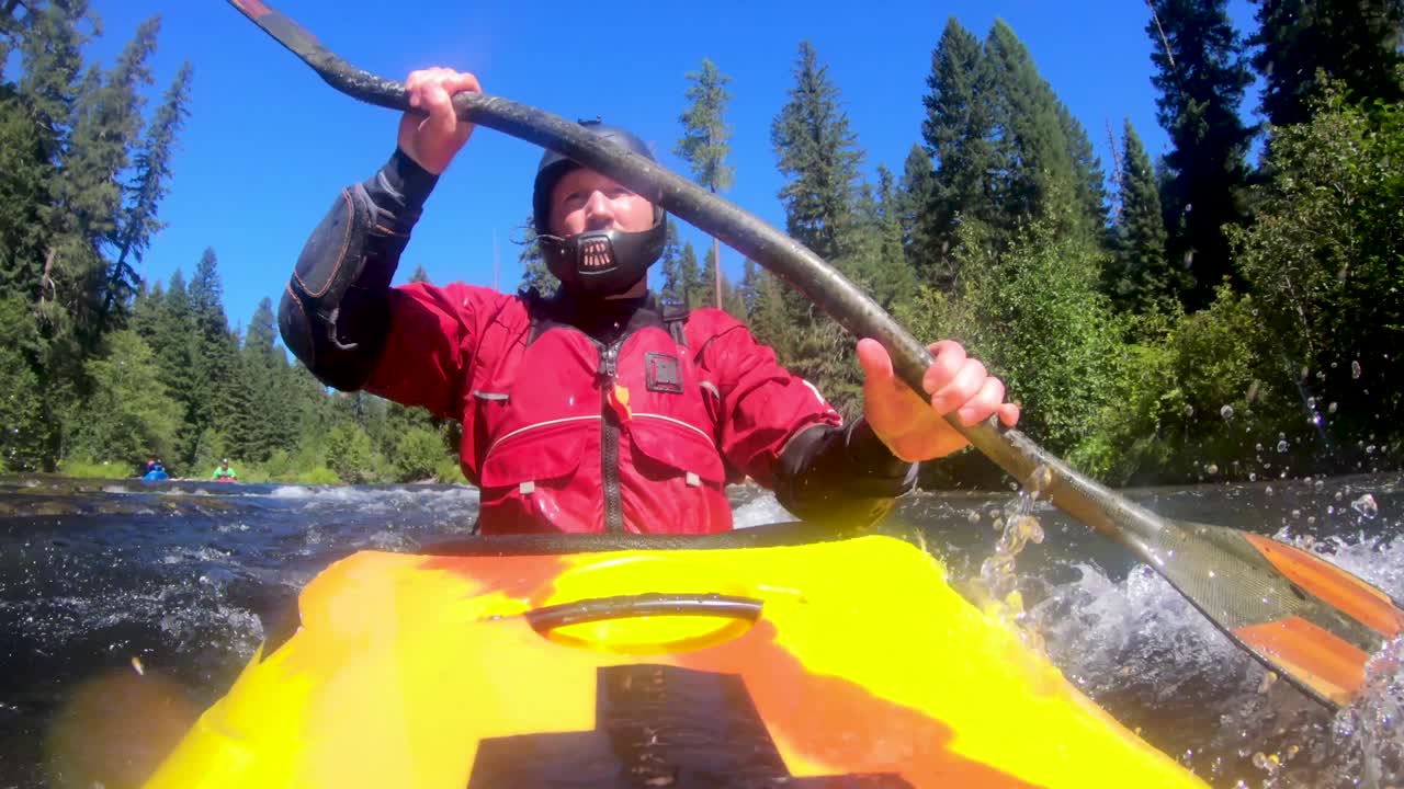 Prospettiva unica di un canoista di acque bianche che scende la sezione River Bridge di classe III del tratto superiore del fiume Rogue nell'Oregon meridionale