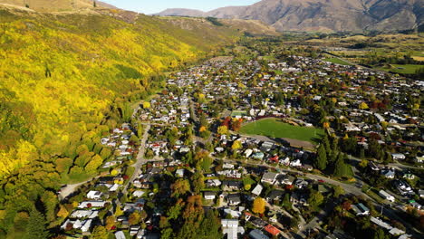 colourful autumn forest by historic gold mining town arrowtown, new zealand, aerial view