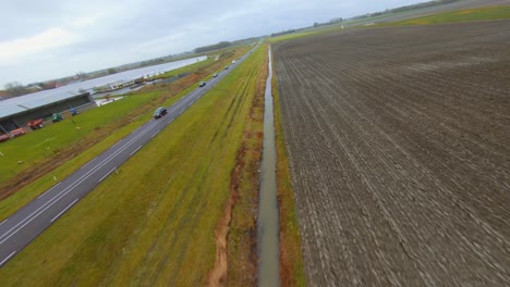 aerial shot going from a small road to the main road surrounded by farm fields