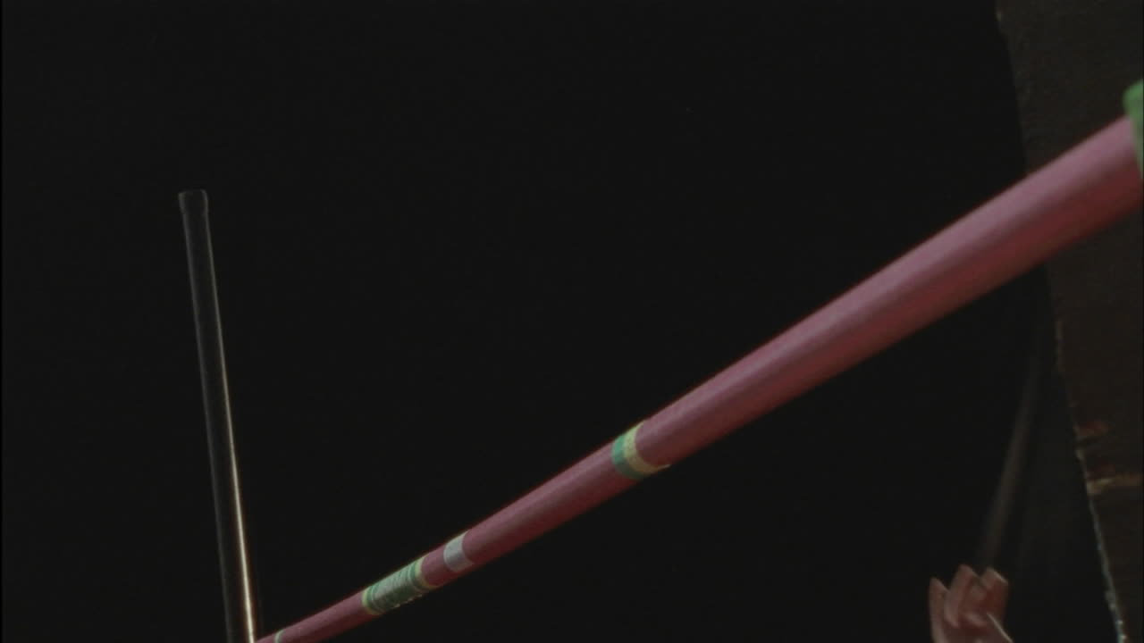 un hombre hace un salto de altura golpeando la barra y haciéndola balancearse