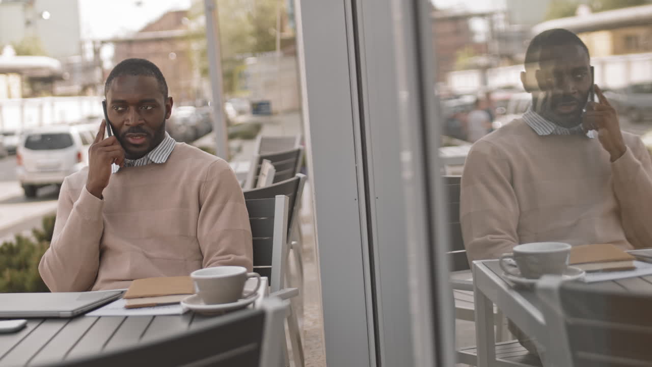 African-American Businessman Talking on Phone Outside Cafe