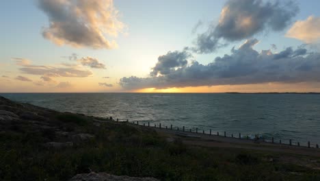 time lapse sunset cloudscape sobre el mar con agua que fluye, vista estática