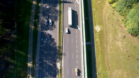 Drone-View:-Panning-Up-Over-Highway,-Following-Vehicle