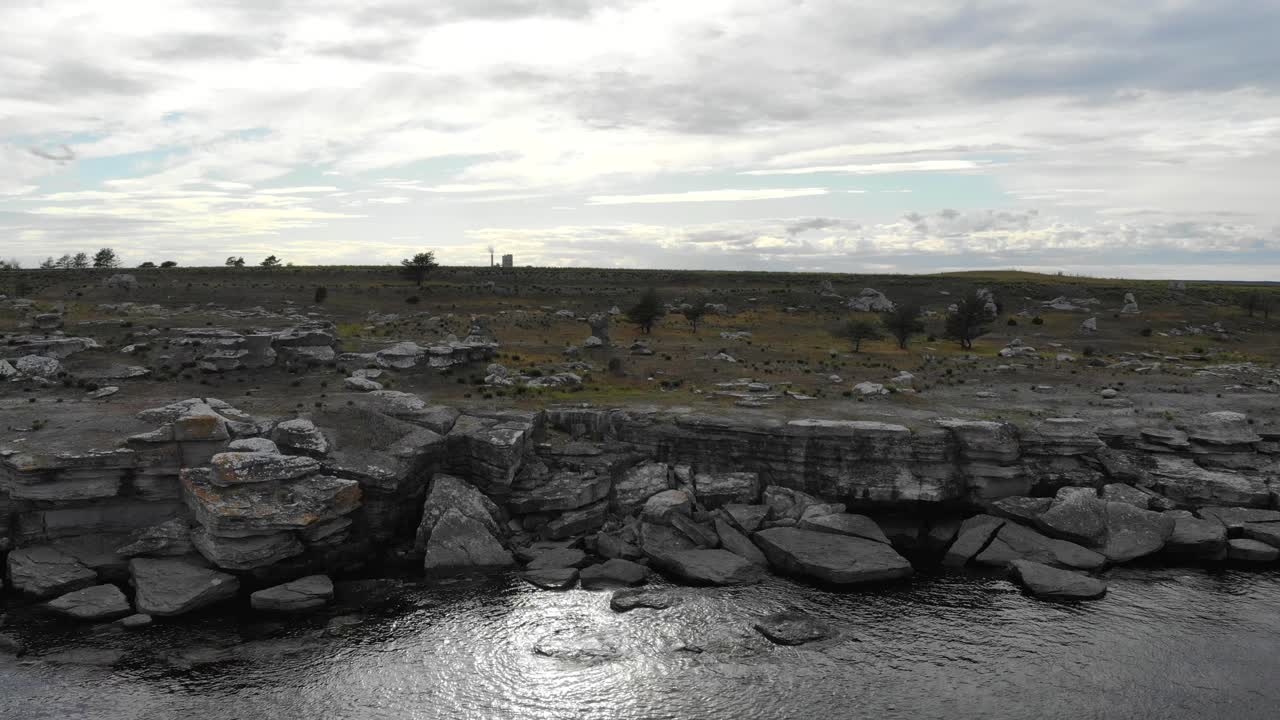 Drone flying over rocky Baltic coastline near Asunden Rauk Field Sweden