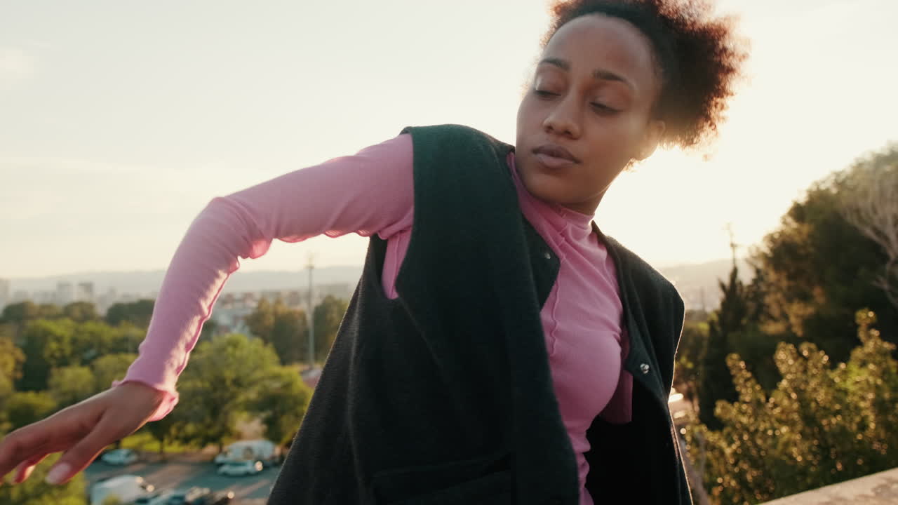 Young Woman Dances Gracefully on Rooftop at Sunset