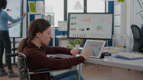 gerente de proyecto mujer con discapacidad que usa computadora y tableta