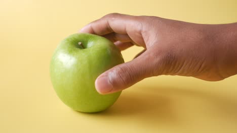 hand reaching for a green apple