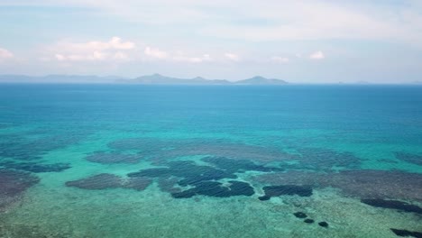 Tropical Ocean With Clear Water And Coral Sea Floor. Drone Pan Right 4K