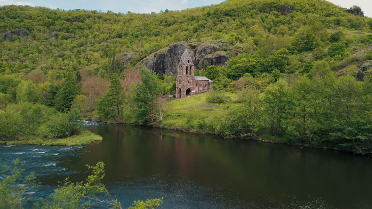 aerial shot revealing Sainte Marie des Chazes Chapel on a sunny day near the Allier River in Haute Loire Departement, Auvergne Rhone Alpes region, France