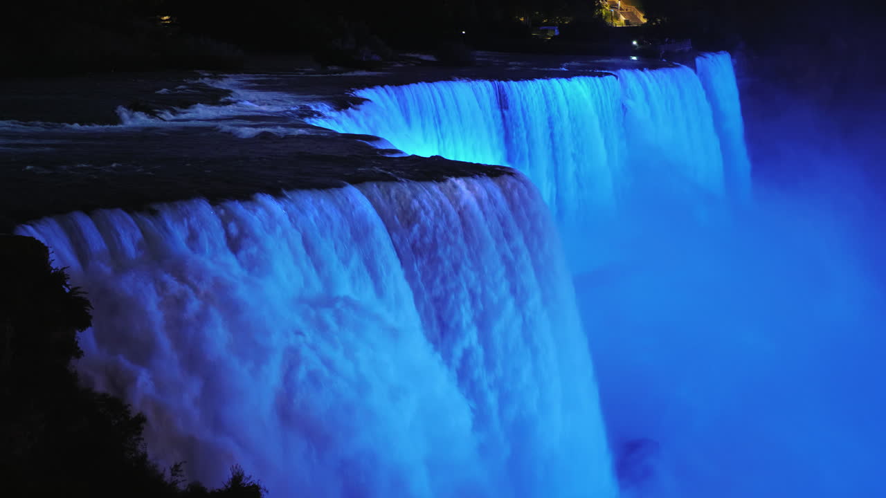 las coloridas cataratas del niágara al atardecer brillantemente iluminadas por focos 4k video