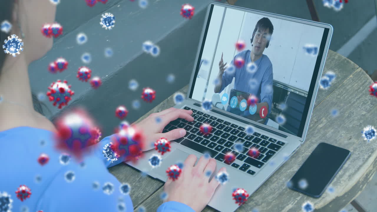 Animation of covid 19 cells over businessman on laptop video call
