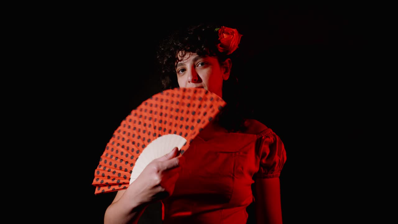 Donna in abito rosso con un fiore che apre e chiude un ventaglio