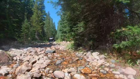 utv going over rocks and stream