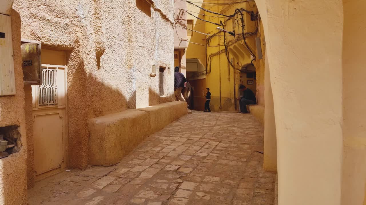 Man Walking Donkey Down Narrow Street in Old Town