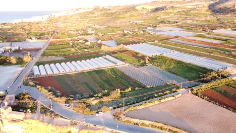 agricultural land of malta with many greenhouses, aerial orbit view