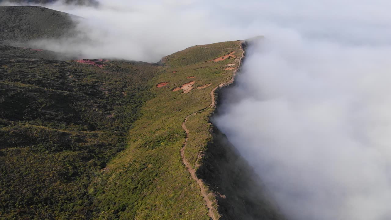 volando sobre verdes colinas y montañas por encima de las nubes en un claro día de verano, hermosos paisajes en 4k