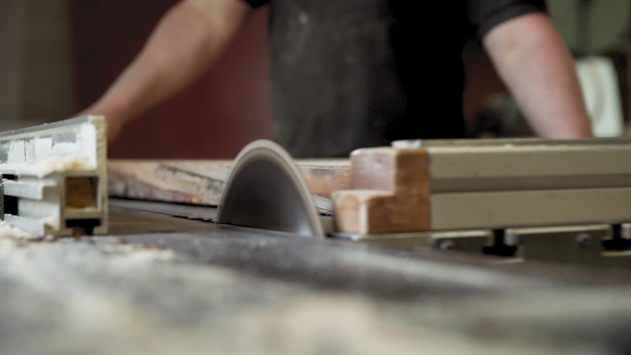 primer plano de una hoja de sierra circular mientras corta madera en una carpintería