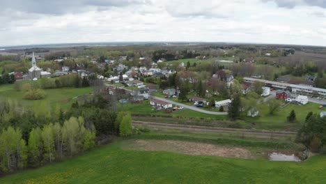 Small-rural-town-with-church-and-steeple-high-above-trees-and-homes