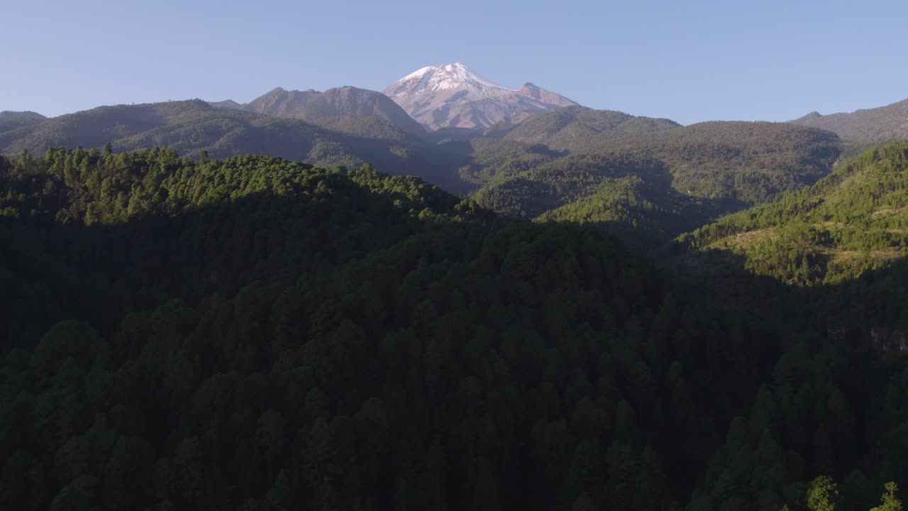 imágenes aéreas del bosque que rodea el volcán, la montaña en el fondo